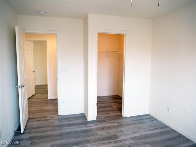 unfurnished bedroom with a closet, baseboards, and wood finished floors