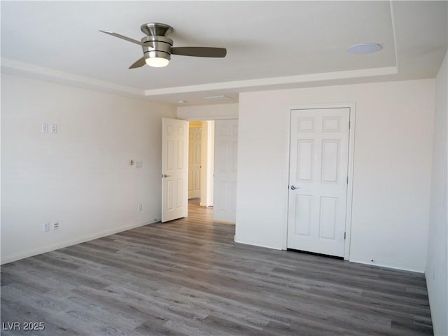 unfurnished bedroom with wood finished floors, baseboards, and ceiling fan