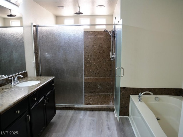 full bathroom featuring vanity, wood finished floors, a shower stall, and a bath