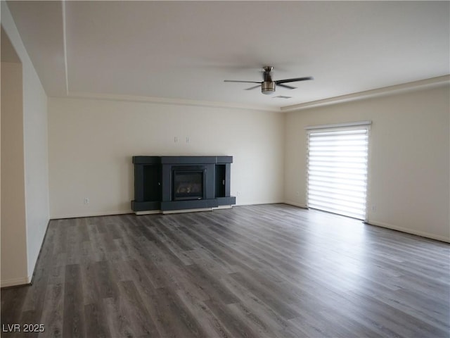 unfurnished living room featuring a glass covered fireplace, wood finished floors, and a ceiling fan