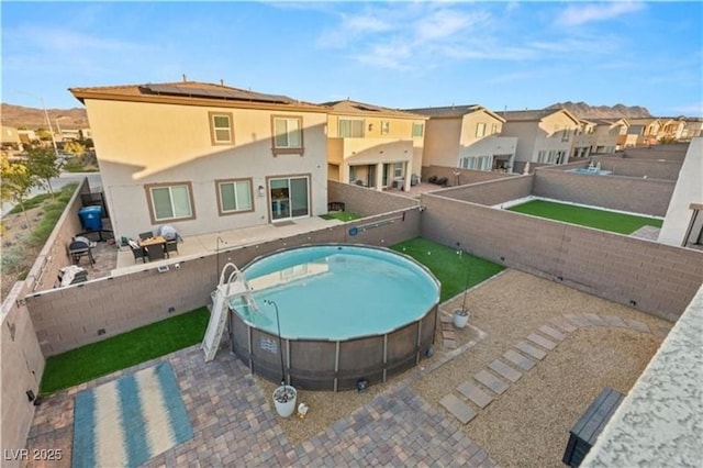 view of pool with a patio, a fenced backyard, a fenced in pool, and a residential view