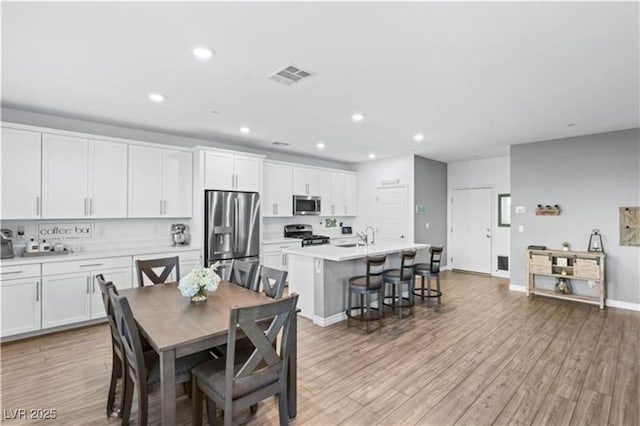 dining space with baseboards, recessed lighting, visible vents, and light wood-type flooring