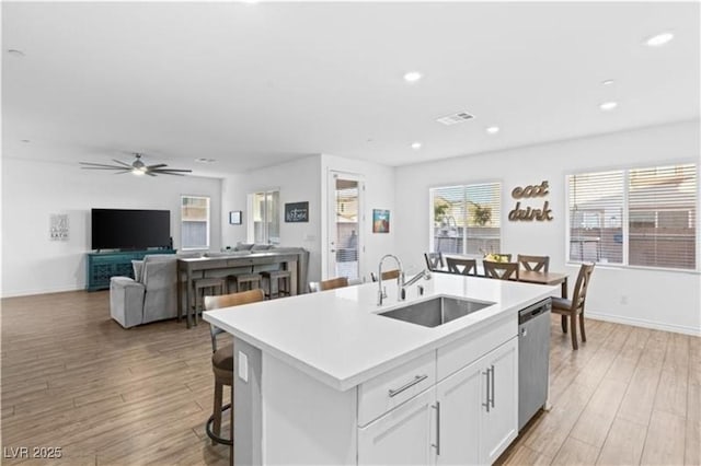 kitchen featuring dishwasher, light wood-style floors, visible vents, and a sink