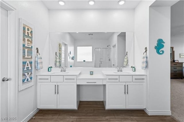 full bathroom featuring a sink, double vanity, and a shower stall