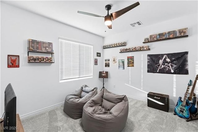 sitting room with carpet flooring, visible vents, baseboards, and a ceiling fan