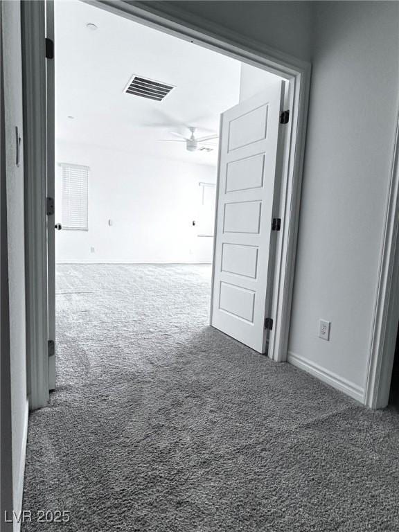 hall featuring carpet, visible vents, and baseboards