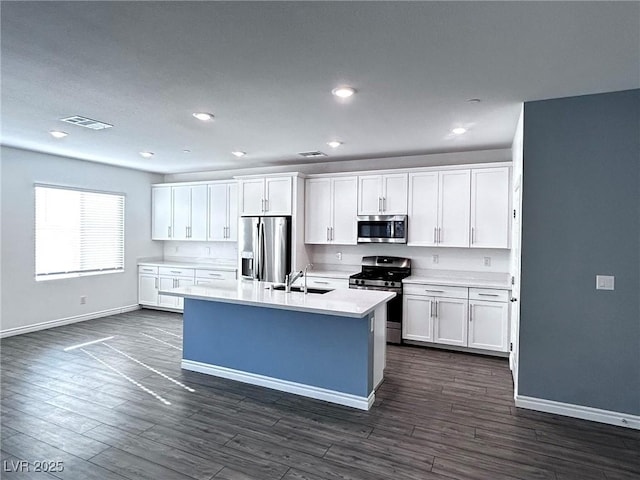 kitchen featuring a sink, visible vents, baseboards, and stainless steel appliances