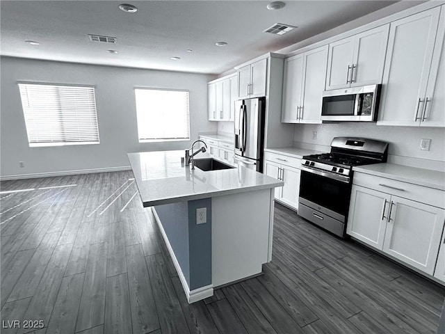 kitchen with a sink, visible vents, appliances with stainless steel finishes, and dark wood finished floors