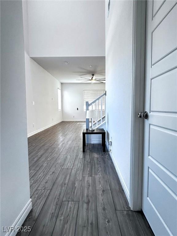 interior space featuring dark wood-type flooring, baseboards, and stairway