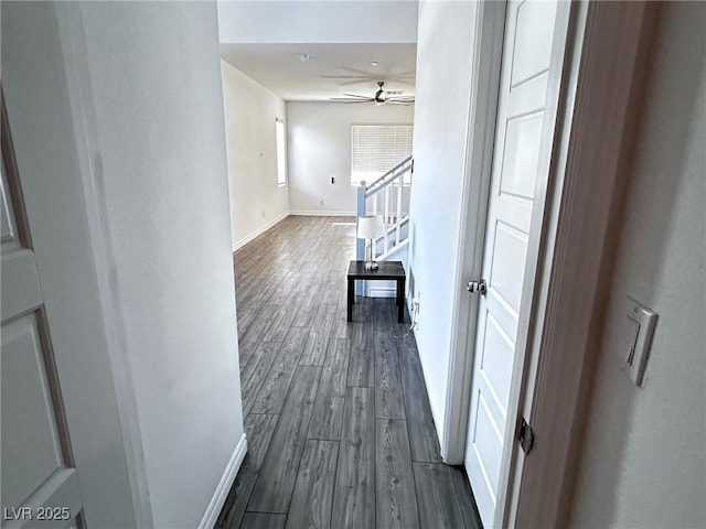 hallway featuring dark wood-style floors and baseboards