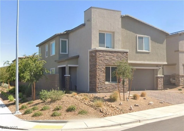 view of front facade with an attached garage, driveway, stucco siding, and stone siding