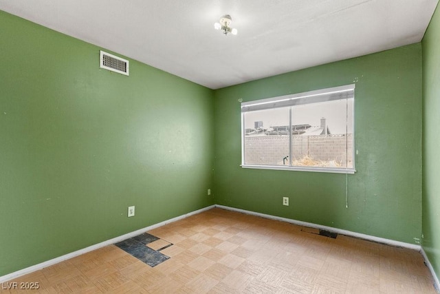 empty room with visible vents and baseboards