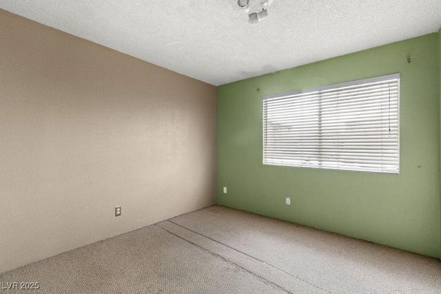 unfurnished room with carpet floors and a textured ceiling