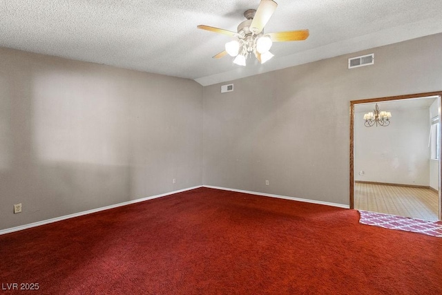 carpeted spare room with vaulted ceiling, ceiling fan with notable chandelier, visible vents, and a textured ceiling