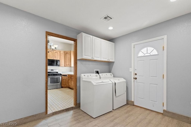 laundry room featuring cabinet space, visible vents, washing machine and dryer, and light wood finished floors