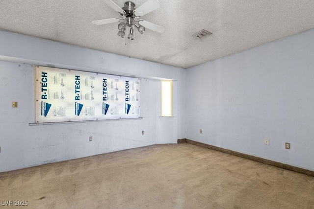 spare room featuring baseboards, visible vents, ceiling fan, a textured ceiling, and carpet flooring