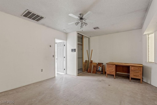 interior space featuring visible vents, carpet, and a textured ceiling