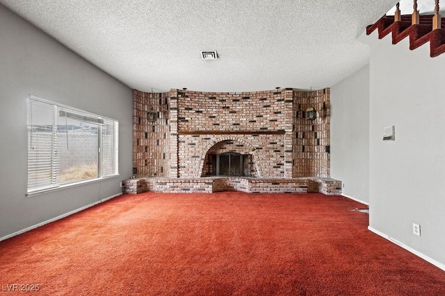 unfurnished living room with baseboards, carpet, a fireplace, and a textured ceiling