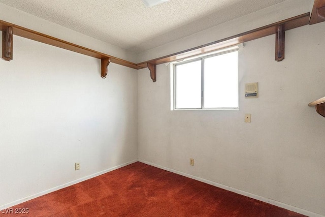 carpeted empty room featuring a textured ceiling and baseboards