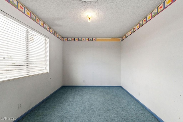 spare room featuring a textured ceiling, baseboards, and carpet floors