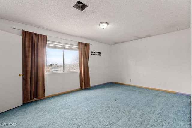 empty room featuring carpet, baseboards, and a textured ceiling