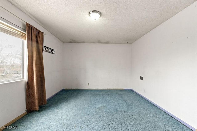 carpeted empty room with baseboards and a textured ceiling