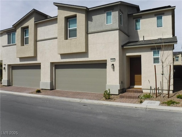 townhome / multi-family property with stucco siding, a garage, and entry steps