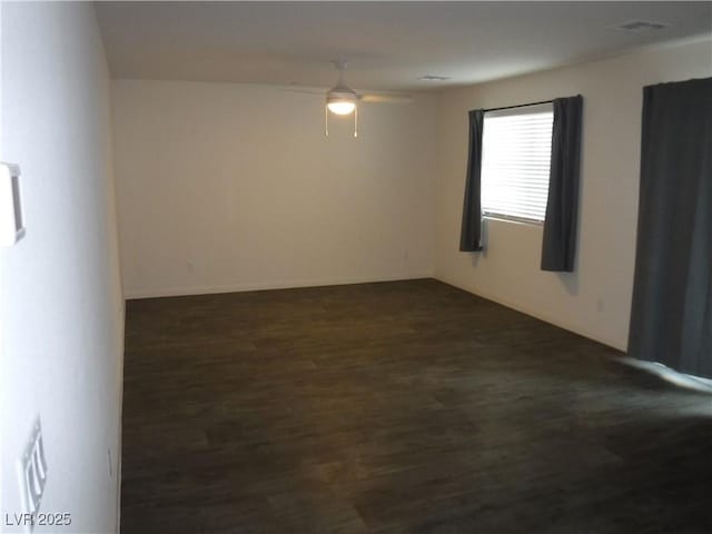 empty room with a ceiling fan and dark wood-style flooring