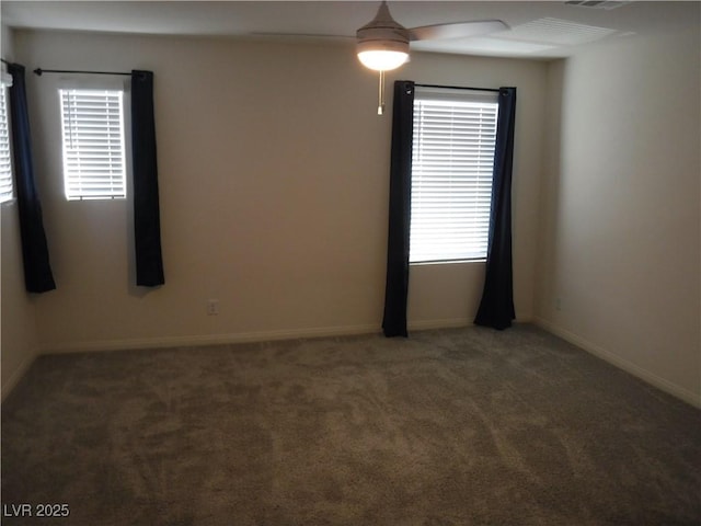 carpeted spare room featuring baseboards and ceiling fan