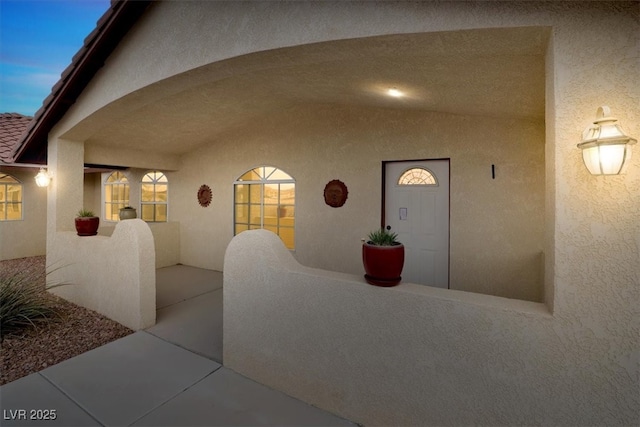 property entrance featuring stucco siding and a patio area