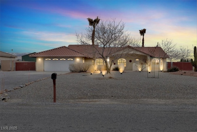 ranch-style home featuring fence, driveway, stucco siding, a garage, and a tile roof