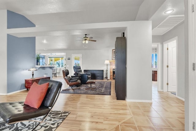 living area with baseboards, visible vents, light wood finished floors, and ceiling fan