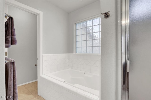 full bathroom featuring a bath, tile patterned floors, and baseboards