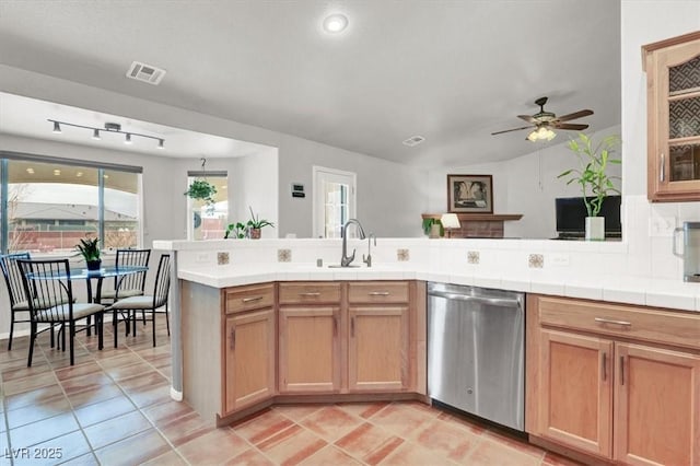 kitchen with visible vents, ceiling fan, tile countertops, dishwasher, and a sink