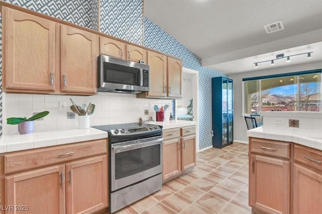 kitchen featuring visible vents, tile countertops, wallpapered walls, and stainless steel appliances