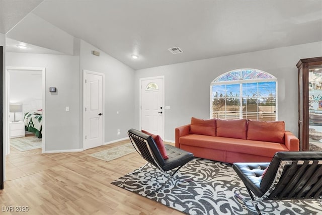 living area with visible vents, wood finished floors, baseboards, and vaulted ceiling