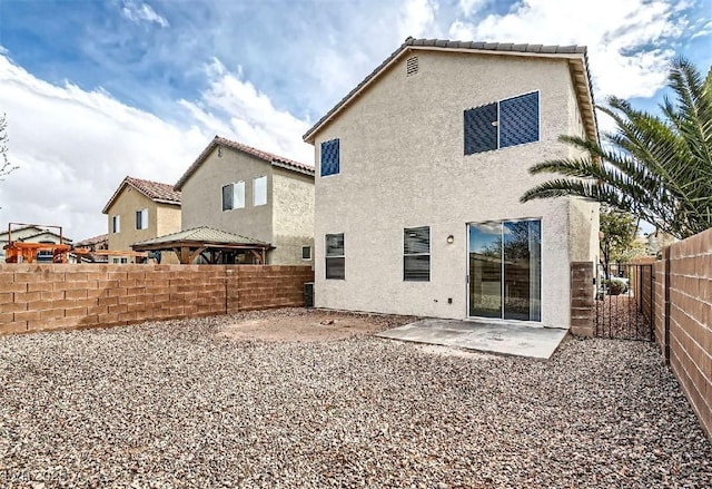 rear view of property with a patio area, stucco siding, and a fenced backyard