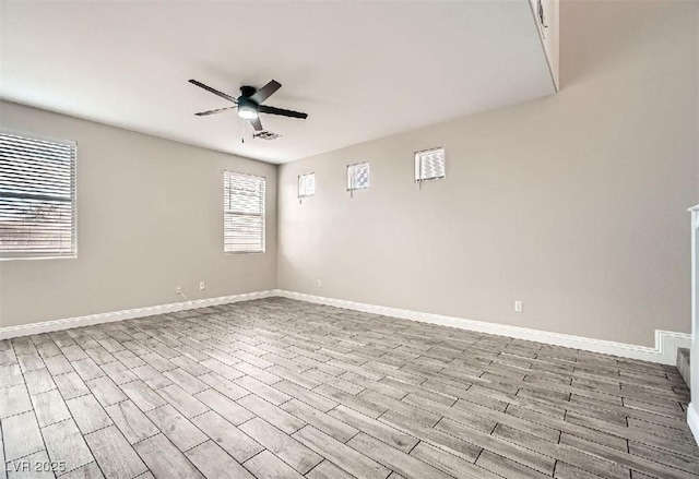 empty room featuring wood finished floors, a ceiling fan, and baseboards