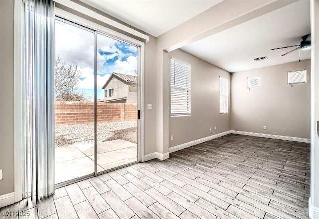 spare room with visible vents, baseboards, ceiling fan, and wood finished floors