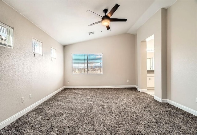 unfurnished room with visible vents, a ceiling fan, carpet, baseboards, and vaulted ceiling