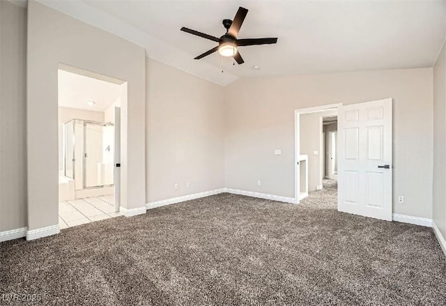 unfurnished bedroom with a ceiling fan, ensuite bathroom, carpet, baseboards, and vaulted ceiling