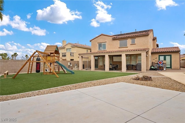 rear view of property with a yard, a fenced backyard, stucco siding, a playground, and a patio area