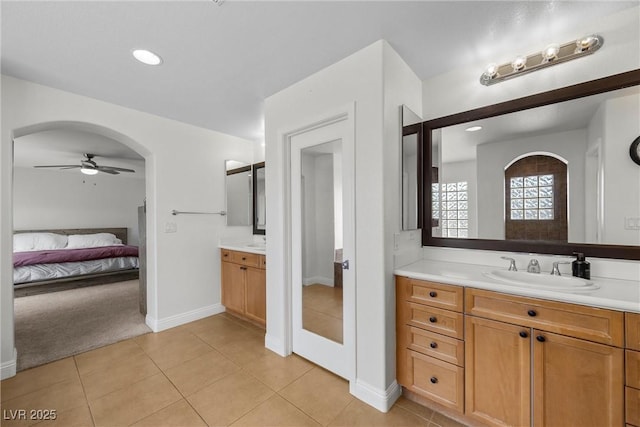 full bath with tile patterned flooring, two vanities, a ceiling fan, and a sink