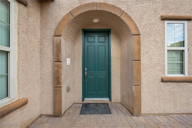 property entrance with stucco siding