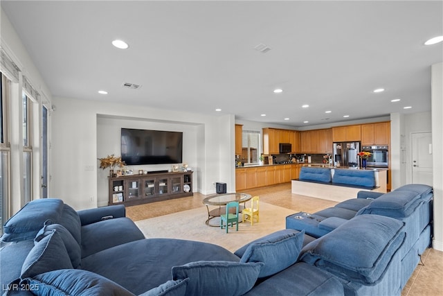 living area featuring light tile patterned flooring, visible vents, recessed lighting, and baseboards