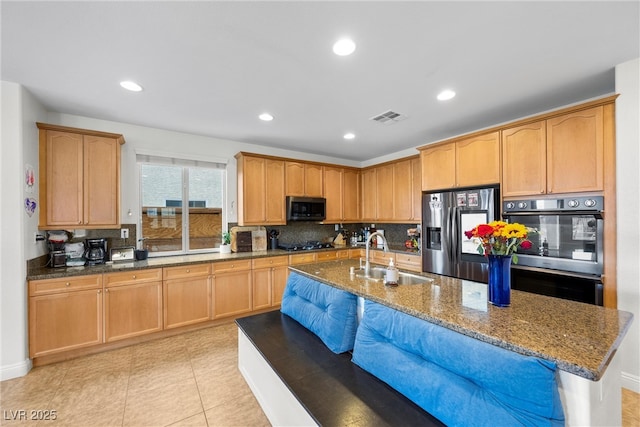 kitchen with visible vents, recessed lighting, dark stone countertops, appliances with stainless steel finishes, and a sink