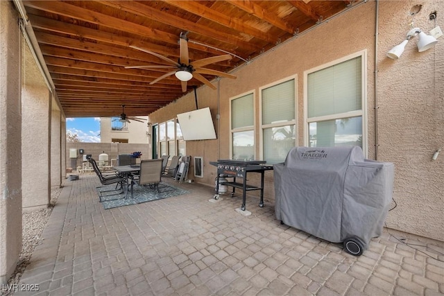 view of patio featuring grilling area, outdoor dining area, and a ceiling fan