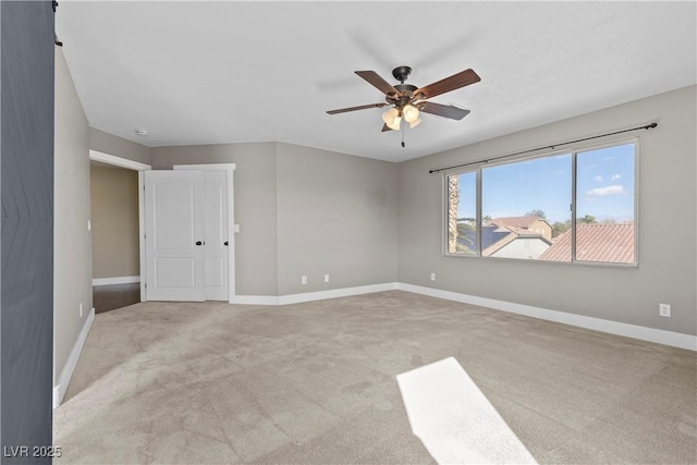 empty room with light carpet, baseboards, and a ceiling fan