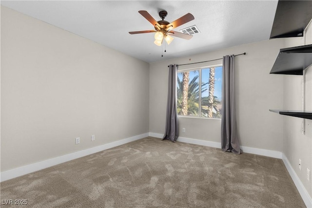 carpeted spare room featuring baseboards, visible vents, and ceiling fan