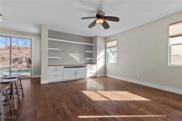 interior space featuring plenty of natural light, baseboards, and dark wood-style flooring